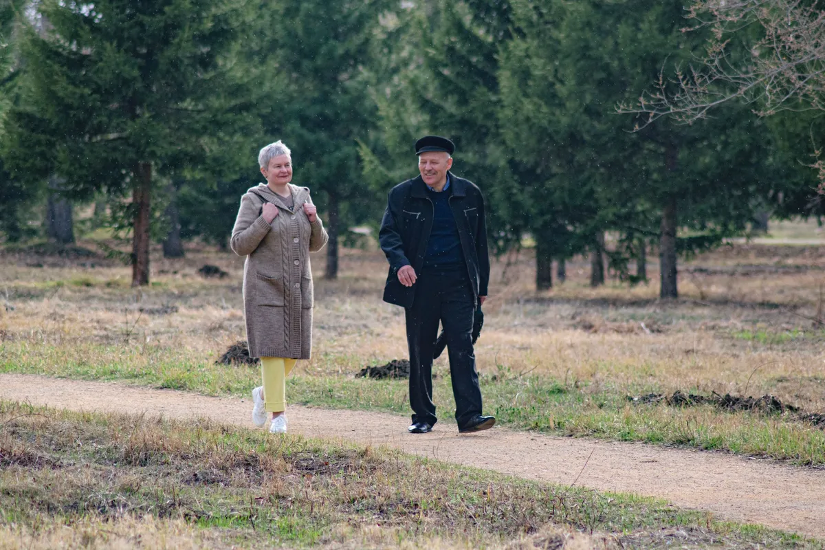Couple de seniors en pleine conversation lors d'une promenade au parc